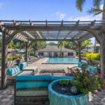 Poolside cabana with lounge style seating and ornamental landscaping