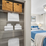 View of a bedroom from inside the walk in closet, with built in linen shelves