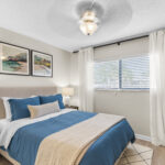 Bedroom with ceiling fan, with blinds and curtains over the window